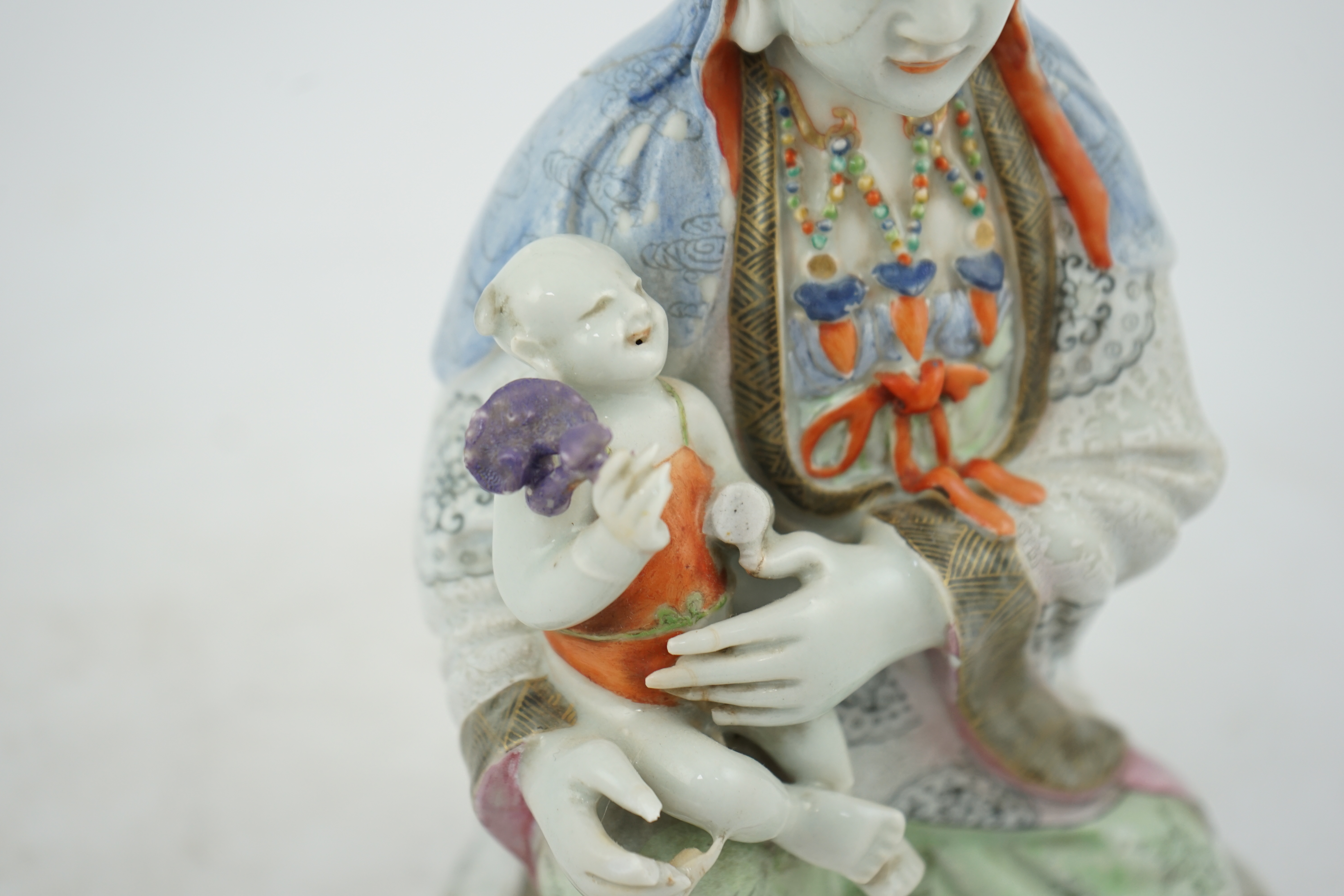 A Chinese enamelled porcelain group of Guanyin holding a child, Qianlong period